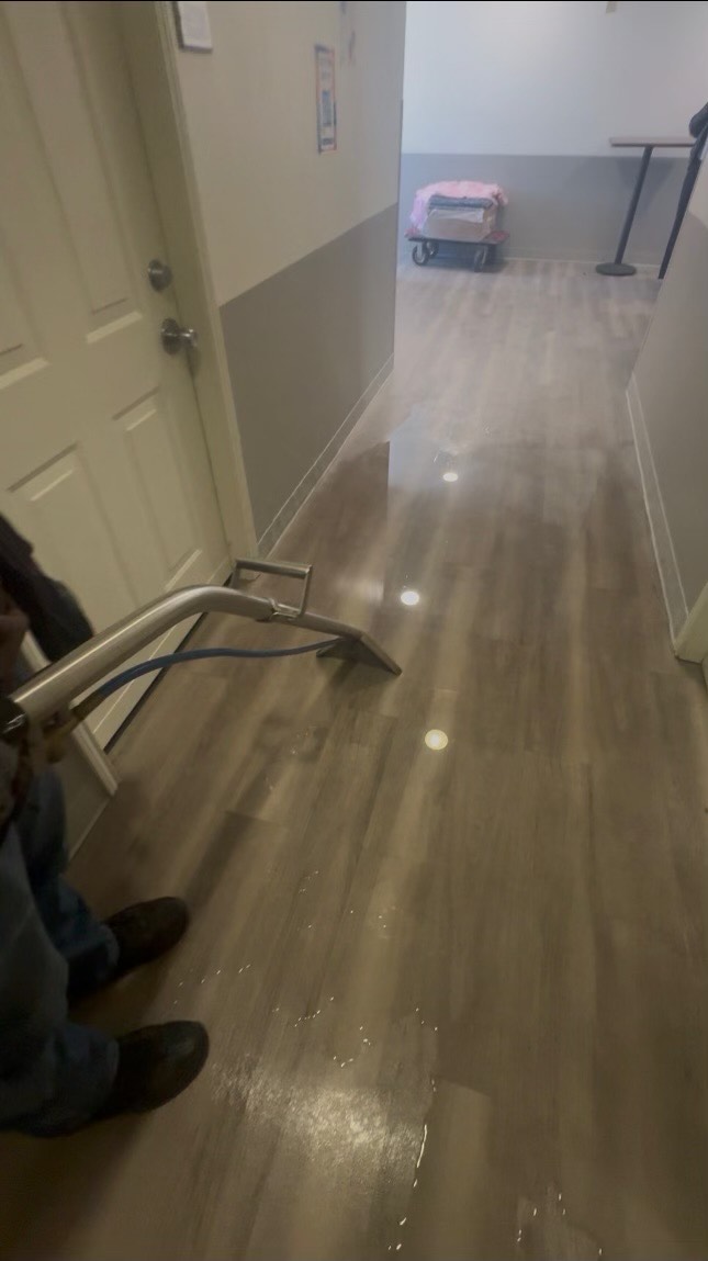 Standing water is vacuumed from a fourth-floor hallway at the University Suites after a pipe burst Monday morning. (Provided/Victor Lopez)